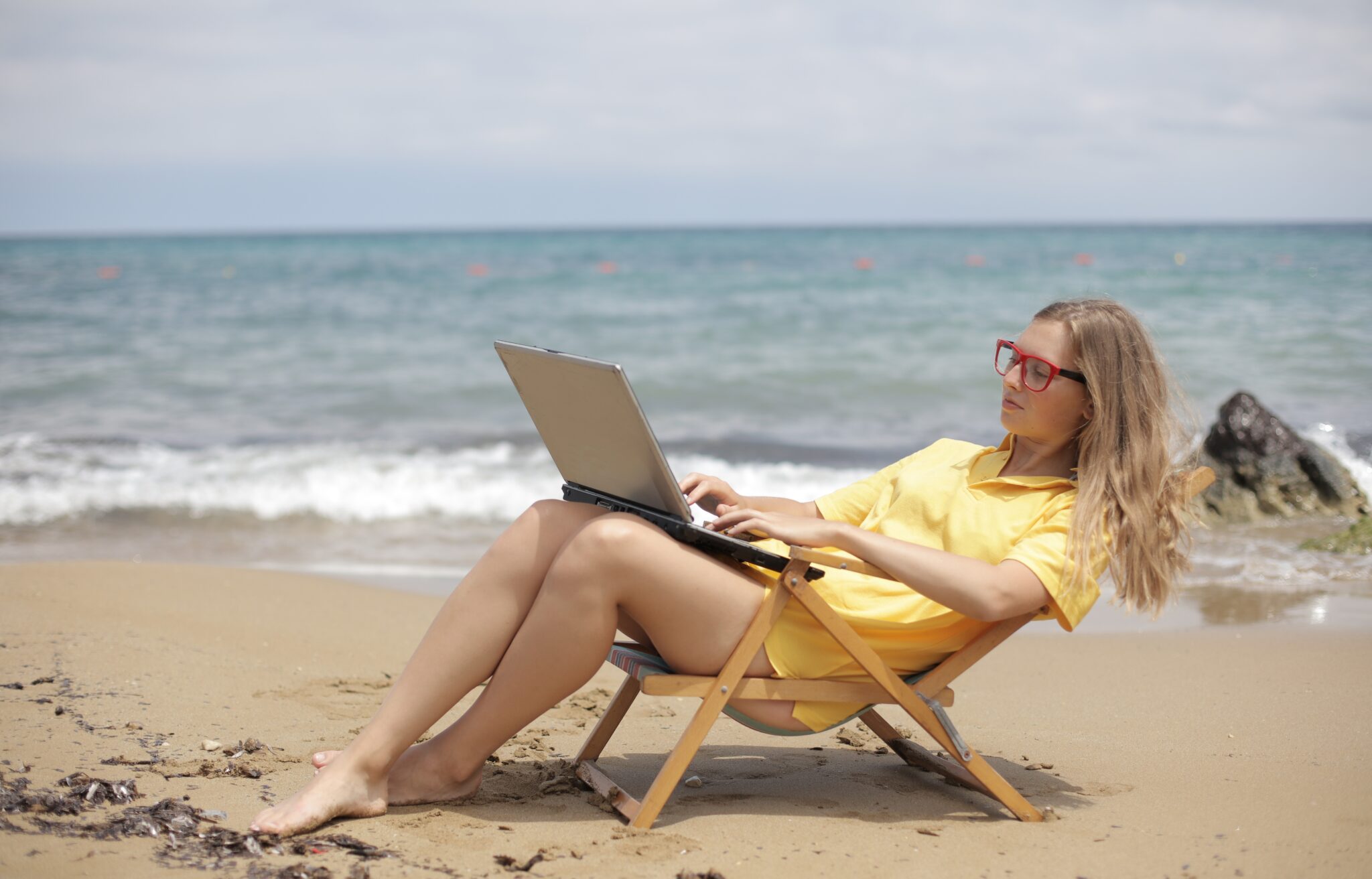 girl on laptop on beach