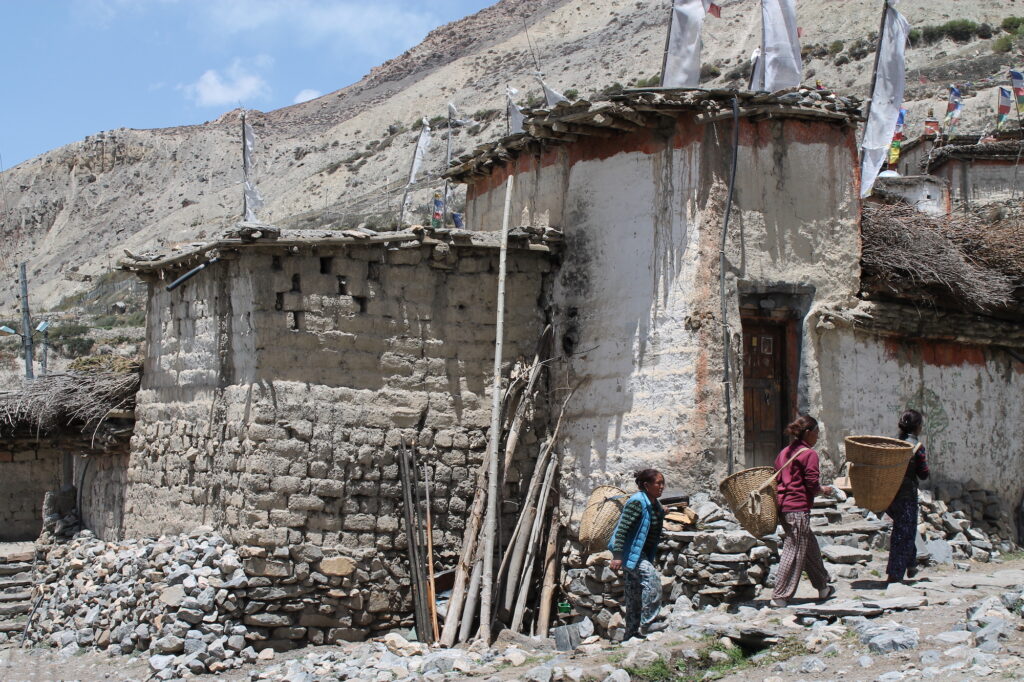 women carrying woven baskets in nepali mountains