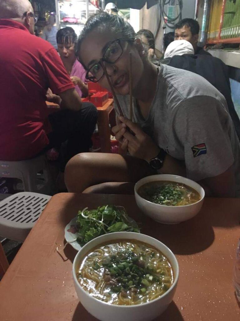 Danika sitting with bowl of noodles in Vietnam.