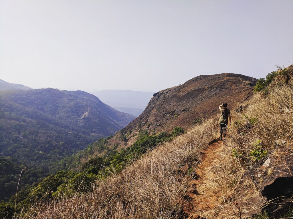 Dee walking down a trail of a hill station in Karnataka, India. #solotravel #travelmemoir #adventuretravel