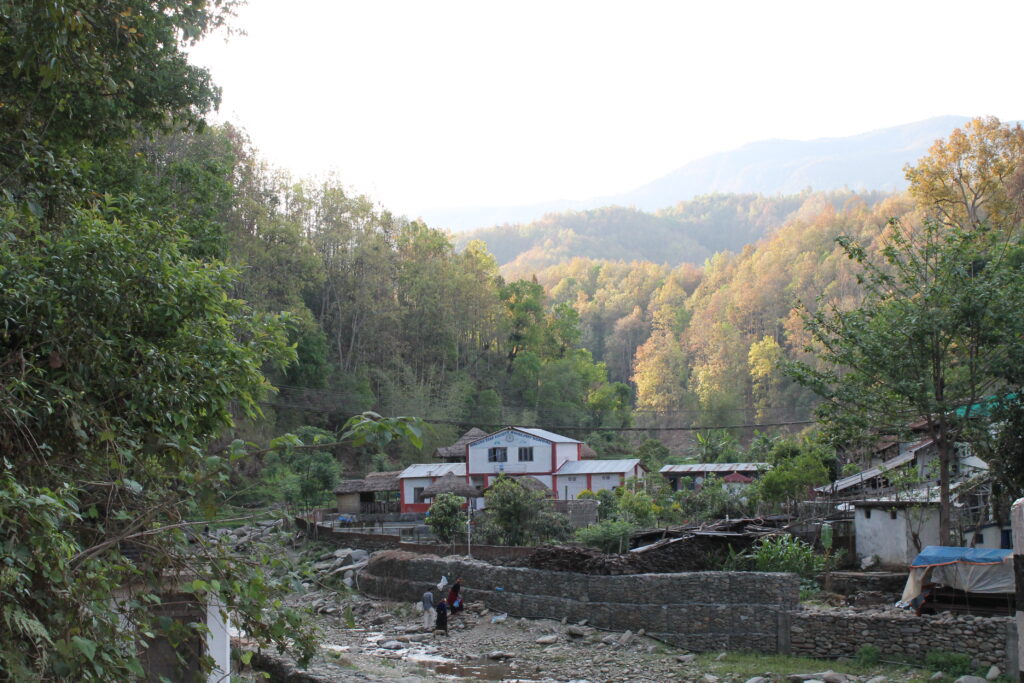 Elementary school beside river surrounded by forested valley.